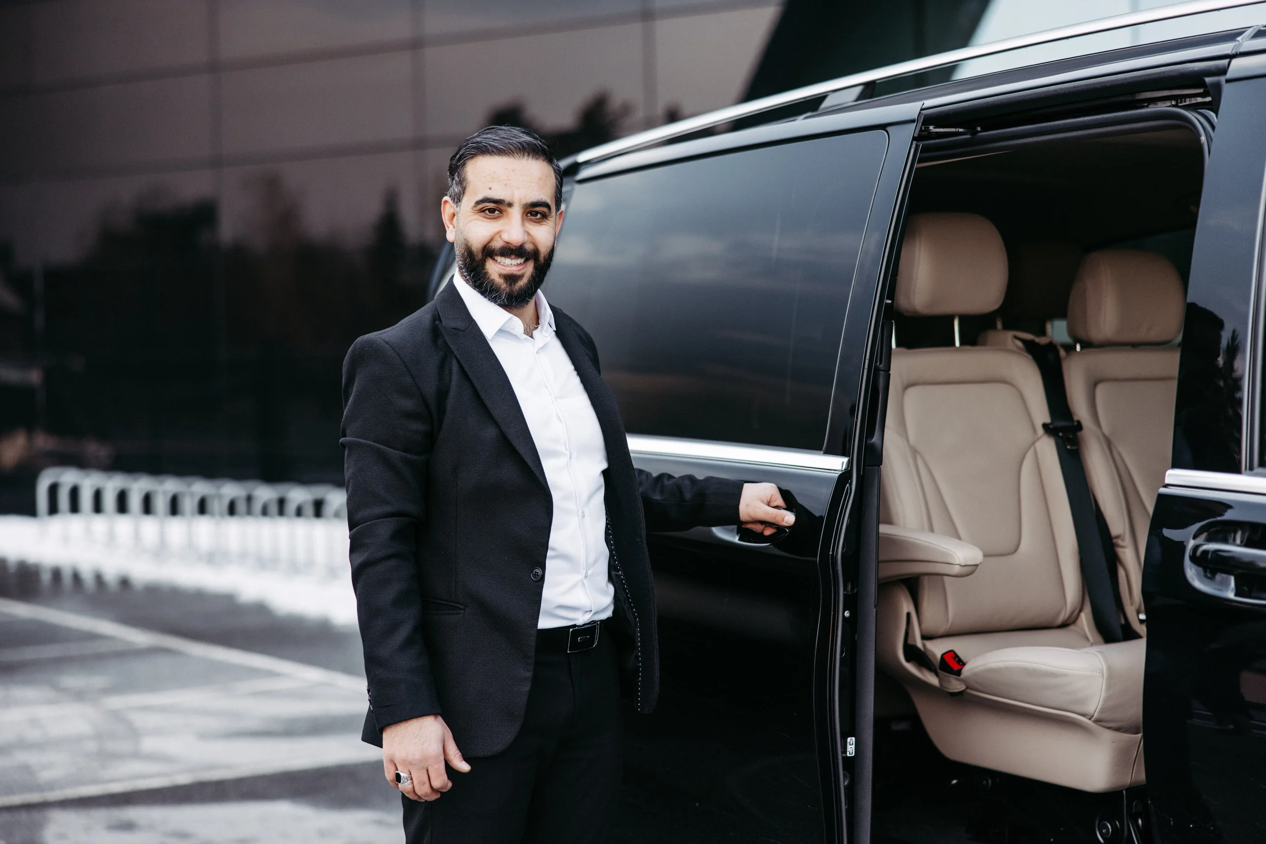 Chauffeur öffnet die Tür einer schwarzen Mercedes-Benz V 300 Klasse Extra Lang